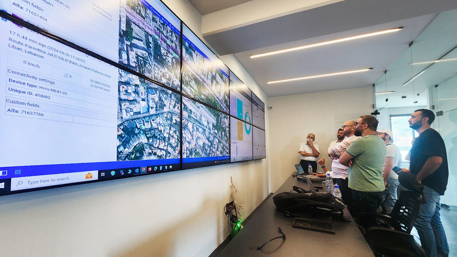 Sala de controle com múltiplos monitores e painéis